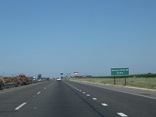 The next two intersections along California 99 north are Vista Avenue and Harvey Pettit Road (noted as being one-half mile north of here on this sign). Vista Avenue travels south, becoming Road 13 upon entering Madera County. Harvey Pettit Road travels east to meet Minturn Road.
