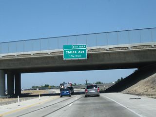Passing under Mission Avenue and Campus Parkway, the next exit from California 99 north is Exit 186A, Childs Avenue and Motel Drive (1.25 miles).