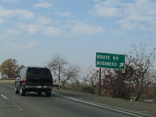 The next exit along California 99 north is Exit 186C, California 99 Business/16th Street. This roadside sign advises that Exit 186C connects to Route 99 Business. The business loop follows old U.S. 99 through Merced and offers all motorist services. It will return to California 99 at Exit 189.