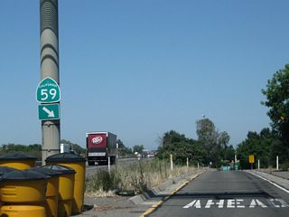 A California 59 south route marker is posted at the bottom of the overhead sign bridge.