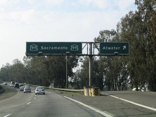Northbound California 99 (Golden State Highway) reaches Exit 194, California 99 Business (Atwater Boulevard) north. This "butterfly gantry" sign was unique in that the California 99 shields cover larger U.S. 99 shields; this sign was removed in mid-2015. California 99 Business will follow Atwater Boulevard north from this interchange and rejoins the freeway at Exit 196.