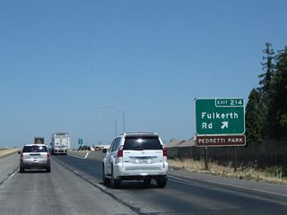 Northbound California 99 meets Exit 214, Fulkreth Road. Use Fulkreth Road east into Turlock; at California 99 Business (Golden State Boulevard), it changes into Hawkeye Avenue.