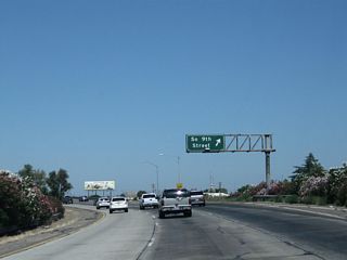 Northbound California 99 reaches Exit 223C, California 99 Business (Ninth Street) north. Like the business route in Turlock, California 99 Business follows Historic U.S. 99 through the city center of Modesto via South Ninth Street. The business route is unsigned from the mainline freeway along northbound, and may be signed sporadically along the city streets it follows through town. Modesto used to be a quiet farming town at the foot of the Sierra Nevada Mountains within the giant, agricultural Central Valley. But as population has exploded in the Valley, Modesto has grown into a regional commercial, agricultural, and industrial center. In addition, some people live here and commute to the San Francisco Bay Area via California 120 and Interstate 205 or via California 132 and Interstate 580. This makes from some early morning and late evening congestion along these routes.