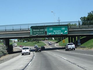 The next exit along California 99 north is Exit 226, Sixth Street to California 108 and California 132. Upon departing at this off-ramp, California 99 threads between two frontage roads. Sixth Street travels northbound only on the east side of the freeway, while Fifth Street travels southbound on the west side of the freeway. So this off-ramp connects directly onto northbound Sixth Street, which in turn travels several blocks until meeting California 108 and California 132 at L Street. California 108 will depart Modesto in a northeasterly direction, connecting with California 120 in Oakdale and meeting California 49 (Gold Country Highway) in Sonora. During the summer months, when the Sonora Pass is open, California 108 passes over the Sierra Nevada at an elevation of 9,643 feet before meeting U.S. 395 northwest of Bridgeport and south of Walker, Coleville, and Topaz. California 132, meanwhile, remains within the Central Valley, extending west to meet Interstate 5 and Interstate 580 and east to reach California 49 in Coulterville, with an extension via Merced County J-20 (J-132) to join California 120 en route to Yosemite National Park.