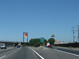 A plethora of service signs are posted overhead at Jack Tone Road interchange.
