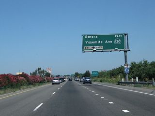 The right lane must exit onto eastbound California 120 (Exit 242). California 120 (Yosemite Avenue) leads to the Sierra Nevada Foothills and Yosemite National Park via Simms, Escalon, Oakdale, Knights Ferry, Chinese Camp, and Groveland. In the summer months, California 120 is open across Tioga Pass before meeting U.S. 395 near Lee Vining in the Eastern Sierra.