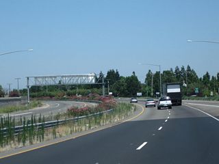 California 99 curves to the northwest as it passes through the Exit 242 interchange (California 120 (Yosemite Avenue) in Manteca.