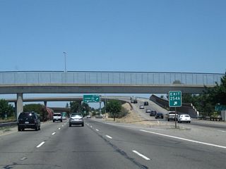 Two lanes transition from California 99 north to California 4 west. The left three lanes continue north.