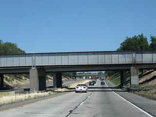 California 99 drops below grade as it passes near downtown Lodi. A pair of bridges pass overhead.
