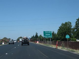 A California 99 north reassurance shield is posted just before a guide sign advising that Exit 277 provides the best route east to Ione.