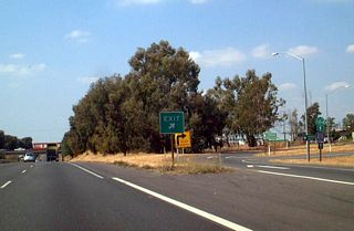 Looking at the exit ramp, we see a route marker assembly that provides directions to both California 104 and Sacramento County Route E-13. This view of the exit ramp is seen from the northbound lanes along the mainline of California 99.
