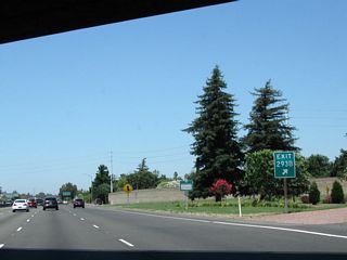 California 99 passes under Florin Road and reaches the gore point with Exit 293B. Summer colors beautify the landscape within the interchange curls.
