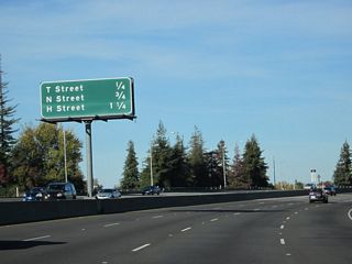 Exit 298C is the beginning of California 51 from the last four lanes. Upcoming exits are at T Street (Exit 6C), N Street (Exit 7A), and H Street (Exit 7B).