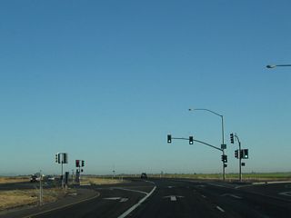 Meeting Riego Road, northbound California 99 continues north as an at-grade expressway with traffic signals.