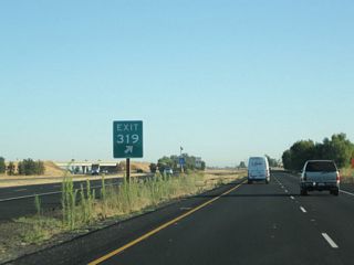 An Exit 319 gore point sign is posted at the separation between California 99 and California 70.