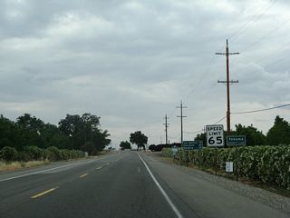 California 99 leaves Butte County and enters Tehama County. A companion mileage sign at the county line provides the distance to Los Molinos (12 miles), Red Bluff (28 miles), and Redding (59 miles).