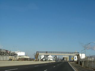 The speed limit on California 103 increases to 55 miles per hour. Built in 1981, the Ultramar Pedestrian Overcrossing passes over the freeway.