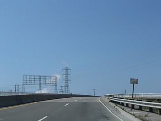A set of Southern California Edison span the Terminal Island Freeway above the Anaheim Street Overcrossing.