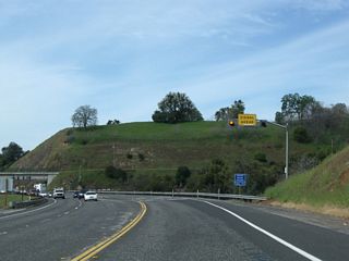 A signal ahead sign is mounted overhead on westbound California 108 prior to Lime Kiln Road and Washington Street.