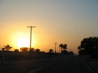 This view looks northwest at sunset along California 115 after the intersection with Imperial County Route S-33 (Miller Road).