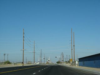 Leaving Calipatria, eastbound California 115 approaches the Union Pacific Railroad crossing. The railroad parallels California 111 from Calipatria north along the eastern shore of the Salton Sea to the Coachella Valley.