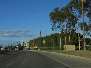 A "Welcome to Holtville" sign is posted along southbound California 115 south and Historic U.S. 80 east. As the highway briefly shifts northeast, the speed limit reduces to 25 miles per hour. This is a major change from the earlier course past rural farms and ranches at 65 miles per hour.