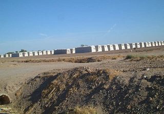 One common feature along the highways of Imperial County are the omnipresent hay bales.  However, this picture shows another baled product of the Imperial Valley: wool.  These white bales do not hold hay; they are compressed piles of wool sheared from herds of valley sheep seen along California 115. These wool bales are located along northbound California 115 just after the at Eddins Road/Wirt Road/West Road intersection just east of Calipatria.