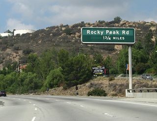 The next exit along California 118 (Ronald Reagan [Simi Valley] Freeway) is Exit 32, Rocky Peak Road, one and one-quarter miles. This section of California 118 passes through some undeveloped, open space, as the freeway connects Los Angeles with Simi Valley.