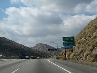 California 118 passes from Los Angeles County into Ventura County along westbound. Rocky Peak Road is the first exit into the city of Simi Valley, even though the urbanized portion of the city is located in the valley west of here.