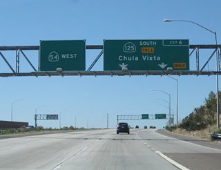 This guide sign provides the lane allocation for California 54 west (Exit 11) and California 125 south (signed as California 54&#039;s Exit 6). Use California 54 west to National City and northern/western Chula Vista. Use California 125 south to eastern Chula Vista and the international border crossing at Otay Mesa.