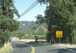 State Route 128 undulates over a series of hills by timberland and vineyards eastward to Mountain House Road.