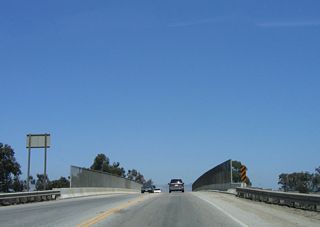 Eastbound California 129 crosses over California 1 (Cabrillo Highway). The initial two-lane highway follows Riverside Drive east toward Watsonville.