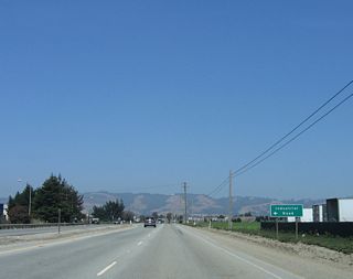 Eastbound California 129/Riverside Drive approaches Industrial Road. The state route passes through mostly agricultural land as it continues east toward Watsonville. Riverside Drive received its name because it follows the Pajaro River, which serves as the county line between Santa Cruz County on the north and Monterey County on the south.