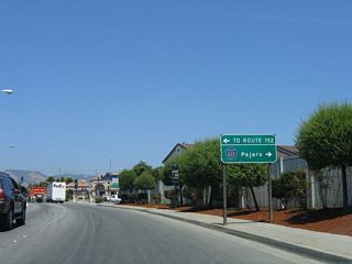 Eastbound California 129/Riverside Drive approaches a major intersection with Main Street. From this intersection, Main Street travels about six blocks north to meet California 152 at Beach Street. For through traffic to California 152 east to Gilroy, continue along California 129 east until the Lakeview Road intersection (or stay on California 129 east to U.S. 101 (El Camino Real), which is faster). This intersection also serves as the junction with Santa Cruz County G-12/Salinas Road south to Pajaro, Royal Oaks, and Prunedale (U.S. 101 and California 156). Santa Cruz County G-12 changes into Monterey County Route G-12 after crossing over the Pajaro River - and at that point, County Route G-12 crosses the county line. Interestingly, the county route shield in this sign says "Monterey County," not "Santa Cruz County." Use Monterey County Route G-12 south to Monterey County Route G-11 (San Juan Road) east to U.S. 101 and California 156 en route to San Juan Bautista and Hollister in San Benito County.