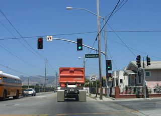 Four blocks later, California 129 approaches Lincoln Street. This major arterial briefly carries a block-long section of California 152 east, then merges onto Freedom Boulevard north en route to Freedom. Only blocks from downtown Watsonville, California 129 passes through residential areas and houses. Note the speed limit of 25 miles per hour is well-enforced.