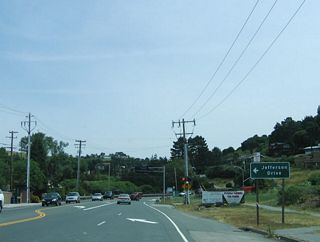 As the right lane ends, eastbound California 131 (Tiburon Boulevard) approaches Jefferson Drive. Another traffic signal is ahead.