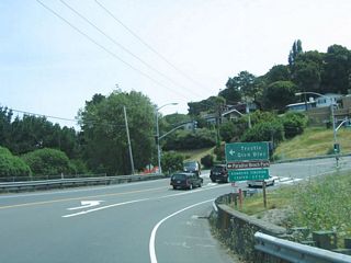 Eastbound California 131 (Tiburon Boulevard) meets Trestle Glen Boulevard at this signalized intersection. Original plans called for California 131 to have an interchange with Trestle Glen Boulevard and a continuation of the four-lane expressway through this area (known as Blackie&#039;s Pasture). This interchange and expressway extension proposal was canceled in 1980. Trestle Glen Boulevard cuts across the Tiburon Peninsula, connecting with Paradise Drive (which follows the north shore of the peninsula). Paradise Beach Park, which is signed, is on the north shore of the peninsula.