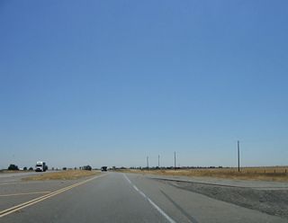 Resuming a four-lane, divided highway configuration, eastbound California 132 merges back onto its own lanes. A stub set of lanes can be seen in this photo for the eventual connection with the other four-lane section west of here.