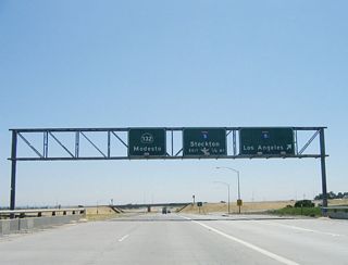 Eastbound California 132 reaches Exit 4A, Interstate 5 south to Los Angeles. The right lane becomes exit only for Exit 4B, Interstate 5 north to Stockton and Sacramento. These Interstate 5 shields look odd because they don't have a white outline, unlike most other signs in the state.