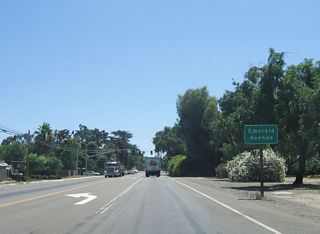 The next traffic signal along eastbound California 132 (Maze Boulevard) is with Emerald Avenue. Note the wide right of way for this two-lane highway, which allows for future expansion.