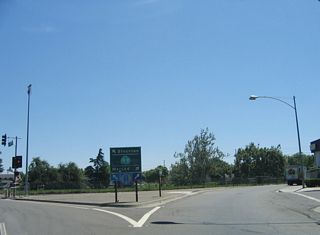 At the intersection with 6th Street, a trailblazer sign for California 99 directs southbound traffic to turn right, while California 132 east traffic continues east into downtown Modesto.