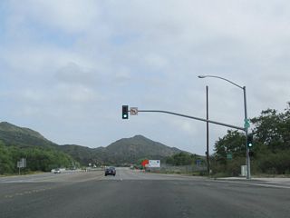 Northbound California 133 (Laguna Canyon Road) meets the on-ramp to California 73 north. A California 133 north reassurance shield is posted on the traffic signal pole.