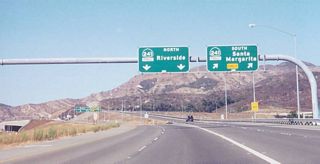 Northbound California 133 (Eastern Transportation Corridor) meets Exit 14A, California 241 (Foothill Transportation Corridor) south to Rancho Santa Margarita. This marks the northern terminus of California 133. Note the subway to the left in the interchange complex ahead; it provides the connection from northbound California 241 to southbound California 133. The left two lanes link to California 241 north via Exit 14B. A toll plaza is placed immediately after the transition from northbound California 133 onto northbound California 241.