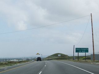 Northbound California 133 (Laguna Canyon Road) approaches the intersection with Laguna Canyon Road. At this intersection, California 133 will divert onto the Laguna Freeway, while Laguna Canyon Road will turn northwest to serve residential and commercial developments of Irvine.
