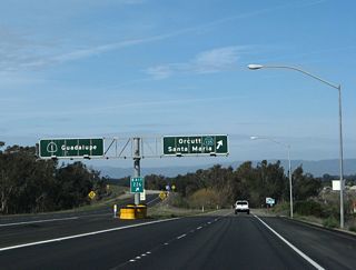 SR 135 combines with SR 1 (Cabrillo Highway) for 3.00 miles heading north toward Orcutt. The two part ways at a wye interchange (Exit 226). Replaced by 2017, these porcelain enamed overhead signs showed the continuation of SR 1 northwest to Guadalupe and SR 135 northeast along Orcutt Expressway to Orcutt and Santa Maria.