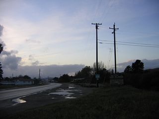 A puddle-strewn turnout provides reflections on a late-day scene along California 135 (Bell Street) north in Los Alamos.