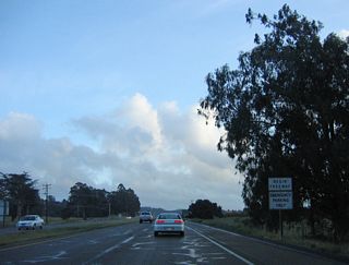 A begin freeway sign is posted after the Foster Road intersection.