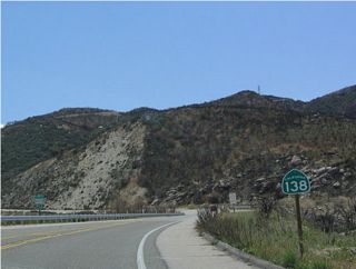This East California 138 shield is located immediately after the California 173 intersection. Note the fire damage on the hillside behind the sign.