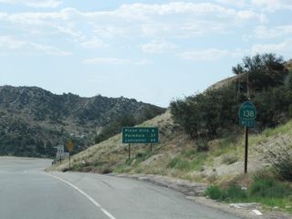 A California 138 west reassurance shield is posted shortly after the California 2 intersection. A mileage sign provides the distance to Pinon Hills (six miles), Palmdale (37 miles), and Lancaster (45 miles).
