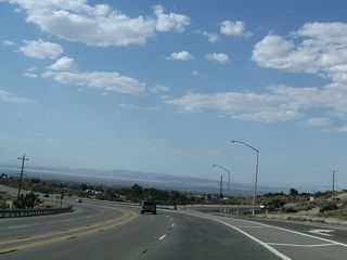 California 138 maintains four lanes near the off-ramp for Sheep Creek Road. The state route curves west at this point.
